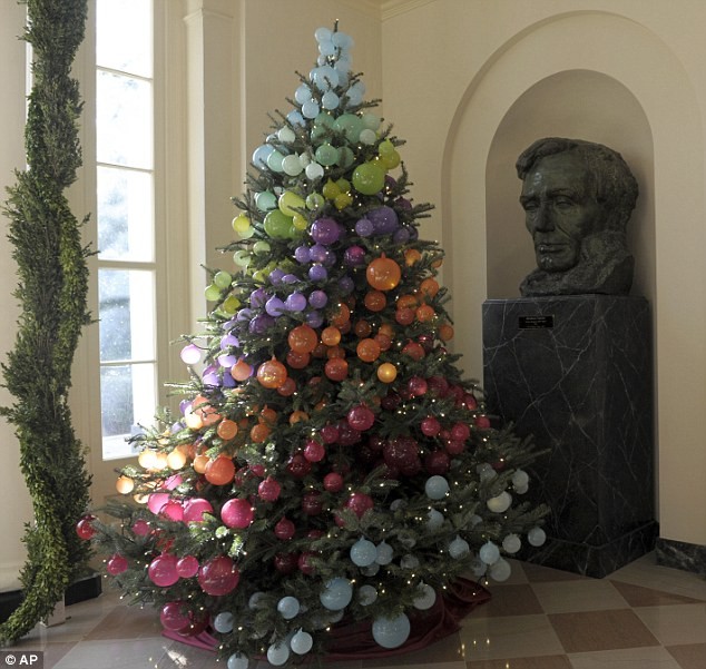 Một cây thông Noel được trang trí trong hình cầu vồng đặt bên cạnh bức tượng của Tổng thống Lincoln trong phòng Vườn Đông của Nhà Trắng.
