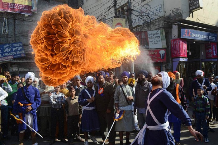 Một người đàn ông biểu diễn màn khạc ra lửa tại đám rước Đền Vàng ở Amritsar, Ấn Độ ngày 27/11.