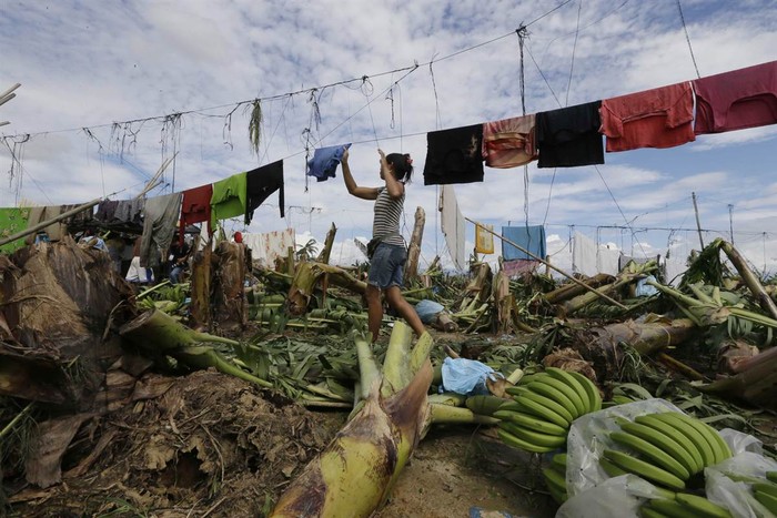 Một người dân Philippines phơi quần áo trên đống đổ nát do siêu bão Bopha gây ra.