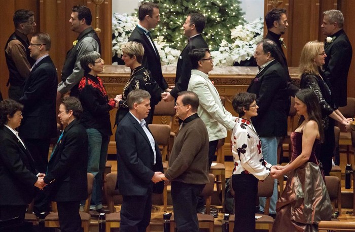 Các cặp vợ chồng đang trao đổi lời thề trong một đám cưới tập thể dành cho 25 cặp đồng tính tại nhà thờ Seattle First Baptist ở thành phố Seattle, Mỹ ngày 9/12. Đây là các cặp đồng tính đầu tiên được phép kết hôn hợp pháp ở tiểu bang Washington.