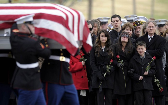 Catherine Stouffer cùng hai người con Shannon (17 tuổi) và Shane (12 tuổi) đi bên cạnh linh cữu của chồng - một cựu sĩ quan Hải quân - trên đường tới nghĩa trang tại Arlington Cemetery ở Arlington (Mỹ) ngày 7/12. Anh Gary Stouffer (37 tuổi) bị giết hại trong một cuộc diễu hành tại Midland, Texas, vào ngày 15/11.