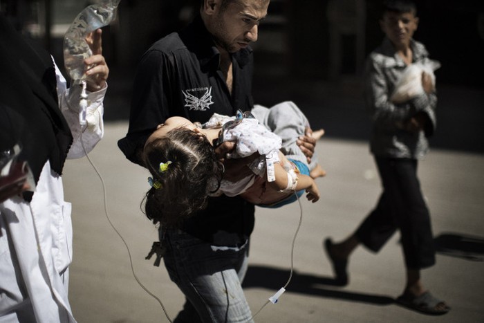 Một người đàn ông Syria bế con gái bị thương bên ngoài một bệnh viện ở Aleppo, Syria ngày 18/9.