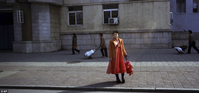 Một phụ nữ Triều Tiên cầm bó hoa giả trên đường về nhà từ một buổi diễn tập diễu hành tôn vinh các nhà lãnh đạo đất nước.