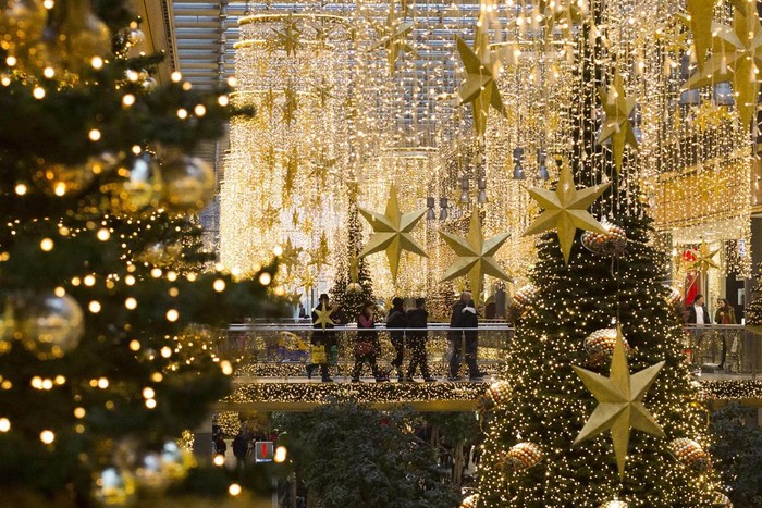 Người đi bộ trong một trung tâm mua sắm được trang trí với đèn Giáng sinh ở Berlin, Đức.