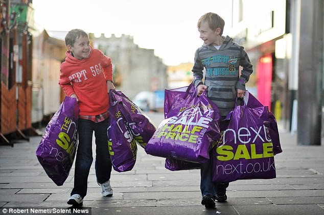 Luke McCarthy (trái) và em trai Nathan xách các túi đồ mua ở Next trong ngày giảm giá tại Southampton.