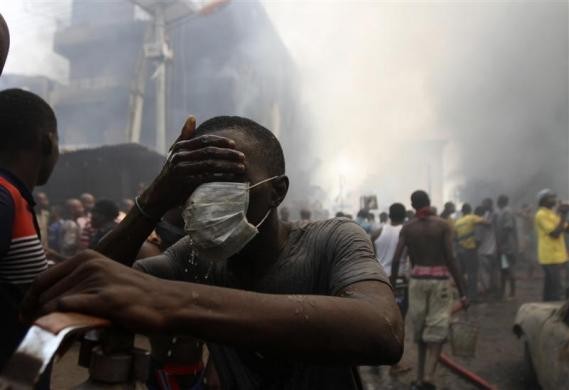 Một tình nguyện viên rửa mặt gần tại hiện trường một tòa nhà chứa pháo hoa phát nổ và bốc cháy ở một khu vực đông dân cư tại quận Isale Eko, thủ đô Lagos, Nigeria hôm 26/12.