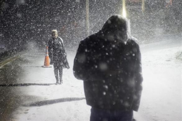 Người dân đi bộ trong trận bão tuyết sau khi tới tưởng niệm các nạn nhân trong vụ xả súng ở trường tiểu học Sandy Hook, Newtown, Connecticut, Mỹ ngày 26/12.