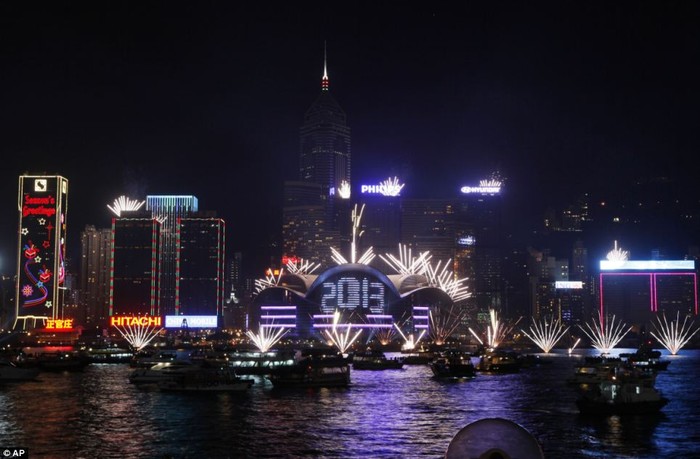 Pháo hoa nổ ở phía trước tòa nhà Hội Nghị Hồng Kông và Trung tâm Triển lãm trên cảng Victoria mừng năm mới 2013.