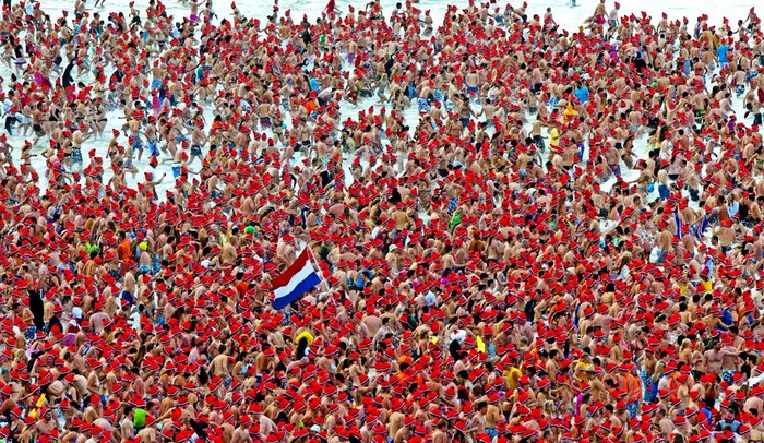 Hàng trăm người đội mũ đỏ đổ xuống Biển Bắc mừng năm mới tại Scheveningen, Hà Lan ngày 1/1.