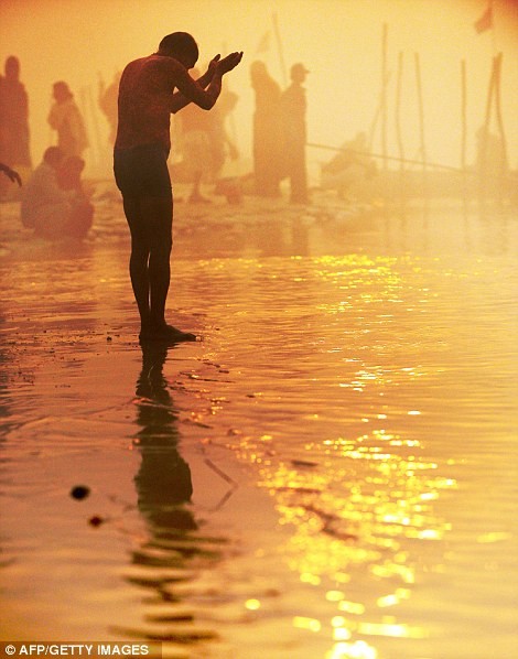 Một tín đồ bày tỏ lòng tôn kính với vị thần Allahabad trước khi tắm nước sông Hằng.
