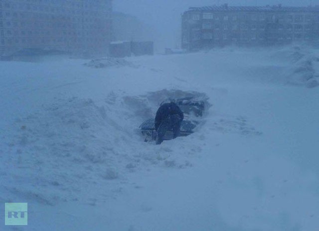 Một người đàn ông nỗ lực đào tuyết để giải phóng chiếc xe hơi của mình tại Norilsk.