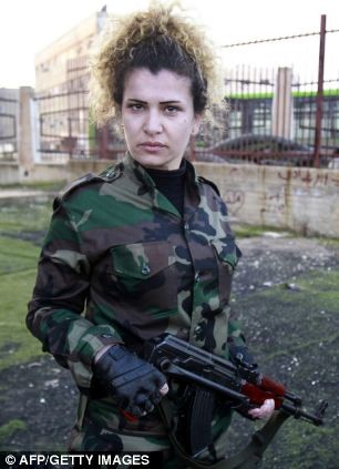 Một nữ nhân viên an ninh Syria mang súng trường tấn công Kalashnikov.