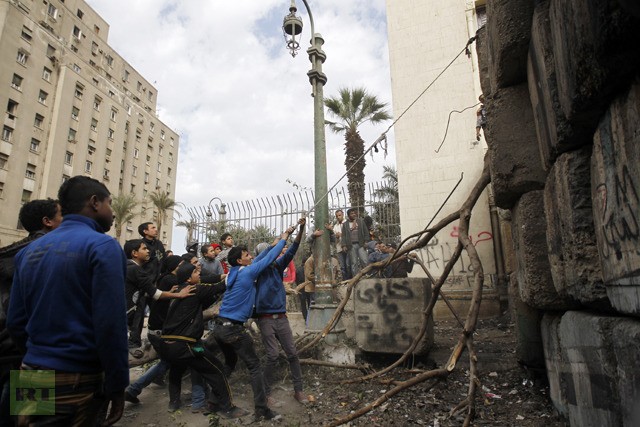 Những người biểu tình Ai Cập đang cố gắng kéo đổ bức tường bê tông khổng lồ bảo vệ dinh Thủ tướng tại Cairo.
