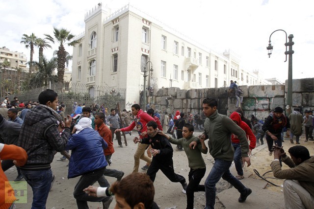 Những người biểu tình Ai Cập bỏ chạy trong cuộc đụng độ với cảnh sát chống bạo động ở Quảng trường Tahrir ngày 25 tháng 1 năm 2013