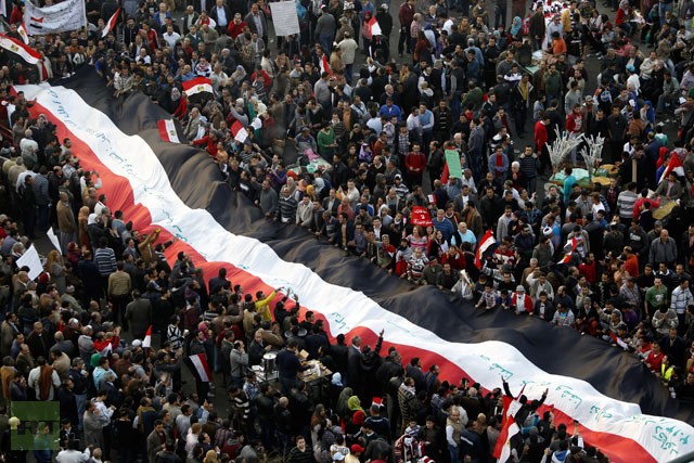 Những người biểu tình phản đối Tổng thống Ai Cập Mohamed Mursi mang một lá cờ khổng lồ tại Quảng trường Tahrir ở Cairo ngày 25 tháng một năm 2013.