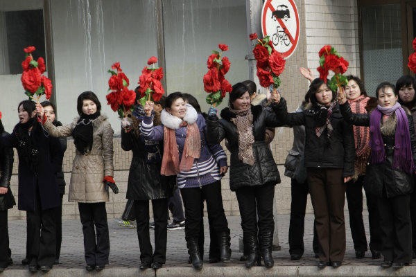 Người dân Bình Nhưỡng cầm hoa đỏ chào đón các "anh hùng hạt nhân" về thăm thủ đô.