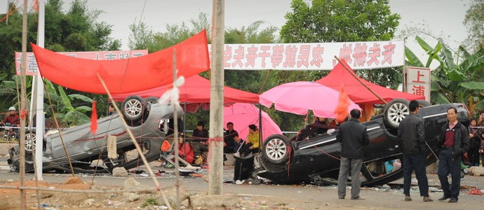 Nhiều xe hơi bị lật nằm rải rác trên đường làng.