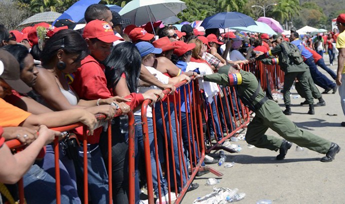 Cảnh sát Venezuela vất vả cố giữ hàng rào chống lại dòng người xếp hàng chờ tới lượt viếng cố Tổng thống Chavez.