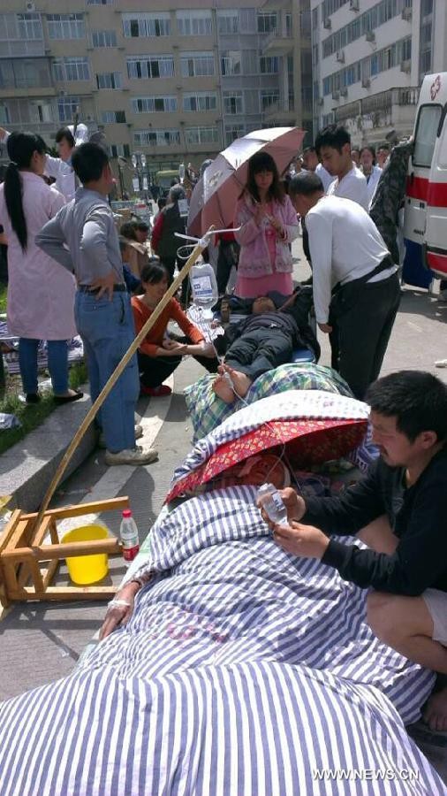 Các nạn nhân của trận động đất nằm ngoài trời nắng trong lúc được hỗ trợ y tế.