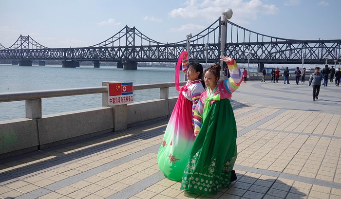 Hai phụ nữ Trung Quốc chụp một bức ảnh trước cầu Hữu nghị Trung-Triều trên sông Áp Lục.
