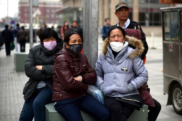 Một nhóm các phụ nữ Trung Quốc đeo khẩu trang khi họ ngồi bên đường phố ở Bắc Kinh ngày 19 tháng 4 năm 2013.