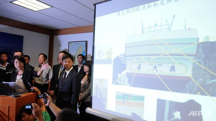 Trần Văn Kỳ (trái) chỉ về phía màn hình hiển thị hình ảnh của lỗ đạn trên chiếc tàu đánh cá trong một cuộc họp báo ở Manila.