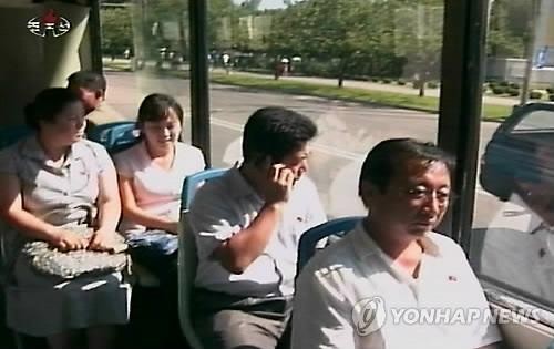 Một người Triều Tiên đang nghe điện thoại di động trên xe bus.