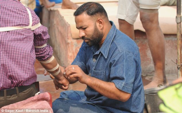 Showkat Ahmed - con trai ông Ghyas chữa bệnh cho người nghèo bên ngoài đường phố ở New Delhi.