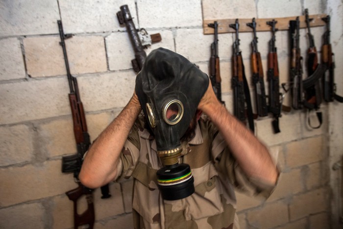 Một phiến quân Syria đang đeo mặt nạ khí tịch thu từ binh sĩ quân đội Syria ở tỉnh Tây Bắc Idlib ngày 18/7.