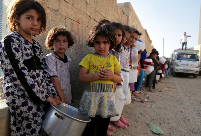 Trẻ em Syria xếp hàng nhận bữa ăn miễn phí trong thành phố Raqqa trong tháng thánh lễ Ramadan của người Hồi giáo vào ngày 14/7.
