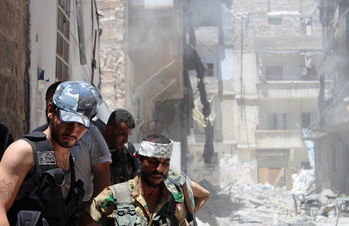 Phiến quân Syria tụ tập bên ngoài tòa nhà họ vừa cho nổ tung để tiêu diệt một tay bắn tỉa của quân đội ẩn bên trong, tại Aleppo vào ngày 10 tháng 7.