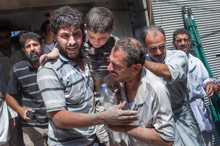 Các tình nguyện viên Syria khóc sau khi giải cứu được bé Fayad Mahmud 8 tuổi.