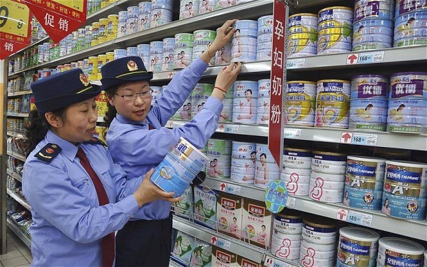 Các thanh tra thị trường Trung Quốc kiểm tra sữa bột tại một siêu thị.