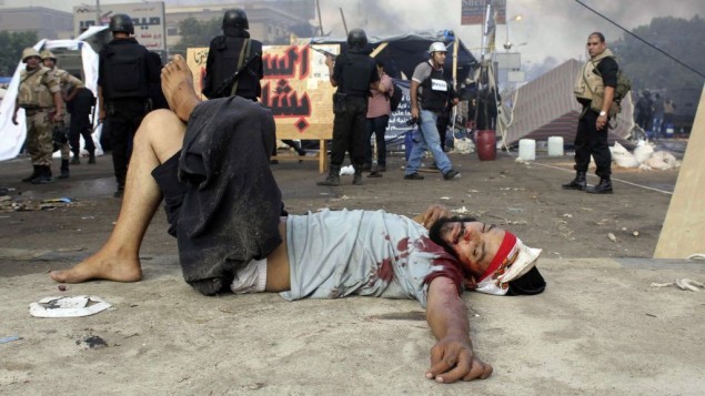 Một người biểu tình bị thương nằm trên đường phố Cairo.