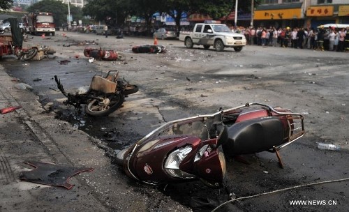 Hiện trường vụ nổ với các xe máy, mảnh kính ô tô vỡ nằm ngổn ngang trên một đoạn đường dài.