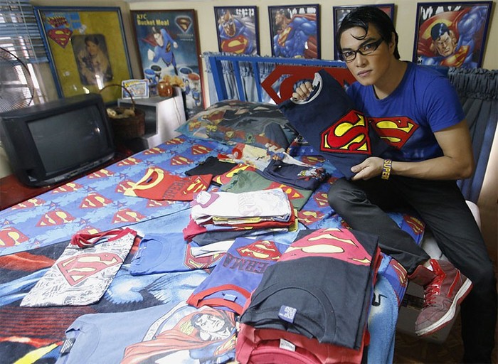 Herbert Chavez khoe hàng loạt áo phông có biểu tượng Superman trên chiếc giường phủ đầy hình ảnh thần tượng của mình.