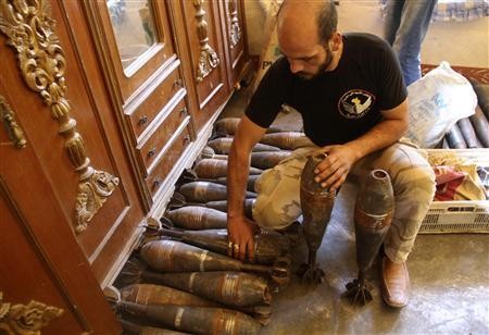 Một tay súng nổi dậy xử lý đạn cối tự chế bên trong một ngôi nhà ở thành phố cổ Aleppo ngày 10/9/2013.