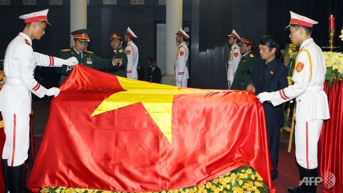 Ông Võ Điện Biên (áo đen, bên phải) cùng các chiến sĩ quân cảnh trong nghi lễ phủ quốc kỳ lên linh cữu Đại tướng Võ Nguyên Giáp.