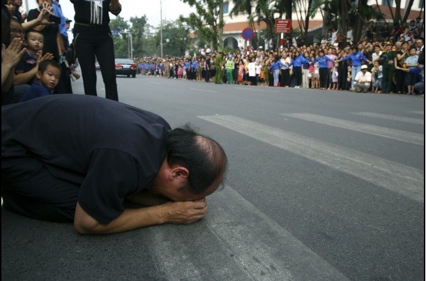 Một người đàn ông quỳ sụp xuống đường khóc khi đoàn xe đưa tiễn Đại tướng đi qua.