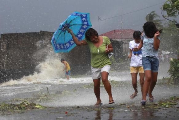 Người dân đi bộ trong gió lớn tại ở Los Banos, Laguna, gần Manila