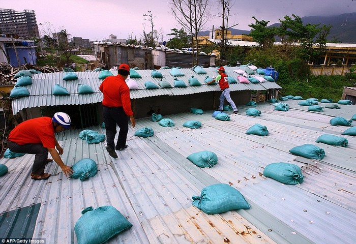Các bao cát được đặt trên mái nhà dân để phòng chống bão.