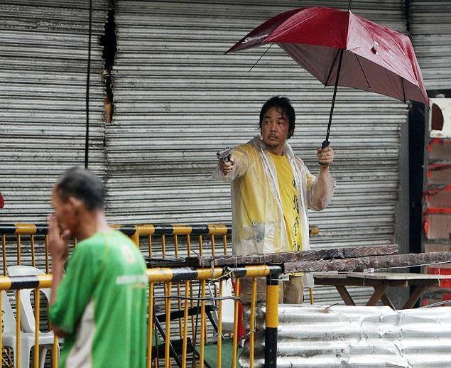 Một người đàn ông ở Tacloban chĩa súng về phía những người khác trong cuộc tấn công cửa hàng thực phẩm tại thành phố sau bão.