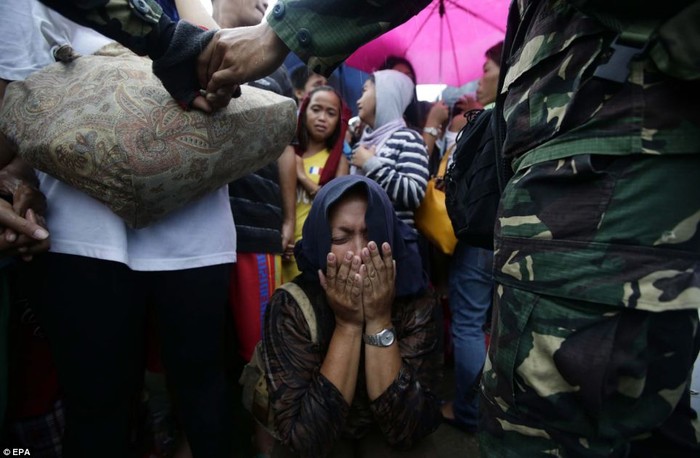 Một phụ nữ ngồi xụp xuống đất òa khóc khi không thể tới được chỗ máy bay di tản