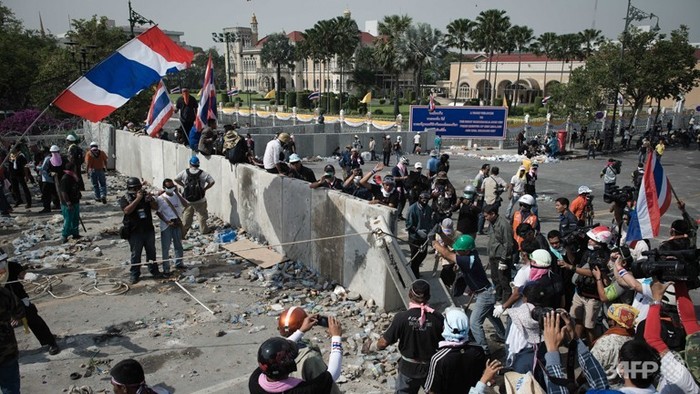 Người biểu tình chống chính phủ quật đổ hàng rào bê tông được lực lượng dựng lên trước đó phía trước tòa nhà chính phủ sau khi cảnh sát bỏ đi.