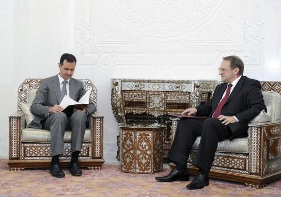 Tổng thống Syria Bashar al-Assad (trái) đọc tin nhắn của cựu Tổng thống Nga Dmitry Medvedev, trong cuộc gặp với Thứ trưởng Ngoại giao Nga Mikhail Bogdanov tại Damascus ngày 29 tháng 8 năm 2011.