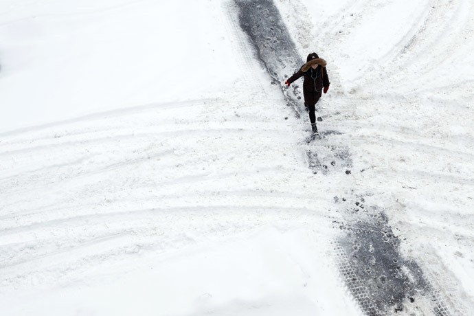 Một người dân đi bộ trên mặt đường phủ đầy tuyết ở Ottawa ngày 22/12.