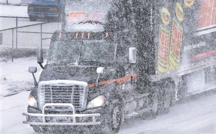 Xe tải ì ạch trên con đường đầy tuyết trắng.