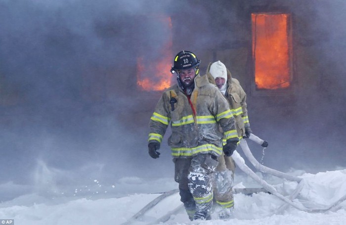 Nhân viên cứu hỏa đấu tranh với lửa và băng tuyết tại một đám cháy trong khu công nghiệp phía nam Brookston, Indiana.