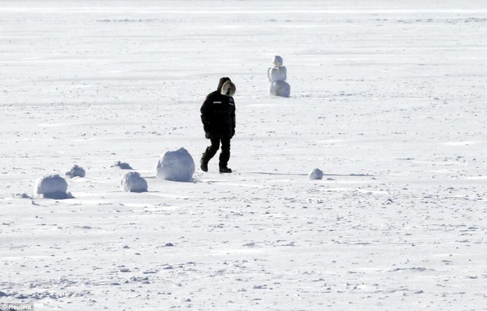 Một người đàn ông đi bộ trên hồ Harriet đã đóng băng.