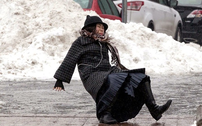 Một phụ nữ bị ngã khi di chuyển trên mặt đường bị đóng băng trơn trượt.
